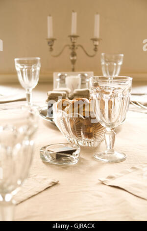 Stoviglie di cristallo con spuntini e candela Foto Stock