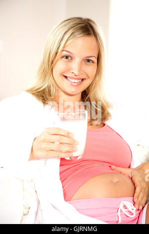 Donna incinta bere latte Foto Stock