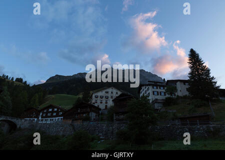 Vista su diversi edifici rurali all'alba in un piccolo paese di montagna nella parte orientale della Svizzera Foto Stock