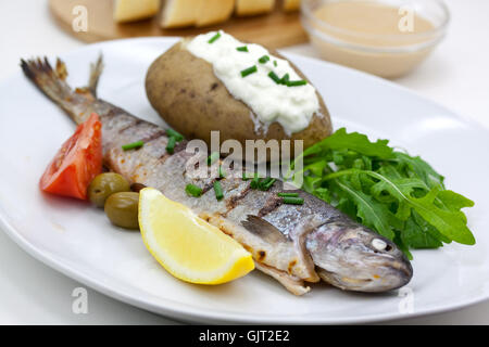 Trota alla griglia con patate al forno Foto Stock