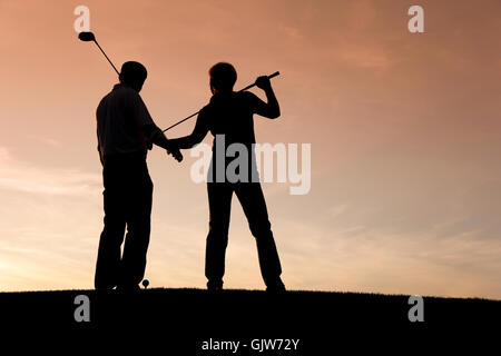 Coppia matura per giocare a golf in sunset Foto Stock