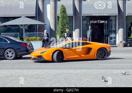 Orange Lamborghini Aventador Coupé essendo paralleli parcheggiato di fronte all' ingresso dell' Hotel D'Angleterre in Copenhagen. Foto Stock