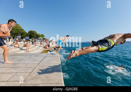 I turisti saltando in acqua vicino l'organo di mare in Zara Foto Stock