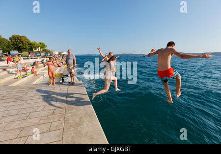 I turisti saltando in acqua vicino l'organo di mare in Zara Foto Stock