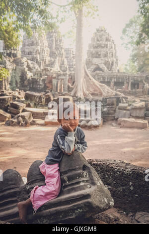 Angkor Wat, Cambogia - Agosto 2007: giovane ragazza seduta sulle rovine di uno dei templi di Angkor Wat complessa, Cambogia Foto Stock