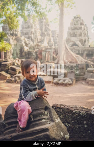 Angkor Wat, Cambogia - Agosto 2007: giovane ragazza seduta sulle rovine di uno dei templi di Angkor Wat complessa, Cambogia Foto Stock