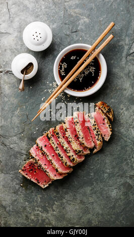 Fette di tonno grigliato bistecca con sesamo e salsa di soia su pietra ardesia board Foto Stock