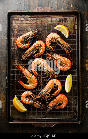 Gamberoni arrosto di metallo sulla placca da forno e limone Foto Stock