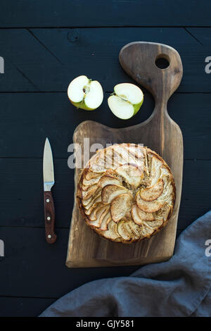 In casa la torta di mele servita con mele fresche rustico di legno scuro su uno sfondo di legno, vista dall'alto Foto Stock