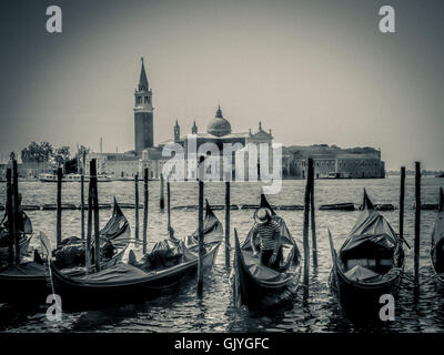 Gondole attraccate in San Marco con il Bacino di San Giorgio Maggiore in background. Venezia, Italia. Foto Stock