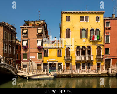 Canal tradizionali edifici laterali con giallo e marrone resi pareti esterne. Venezia, Italia. Foto Stock