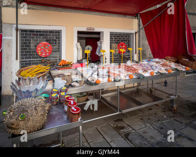 Bancarella vendendo il pesce appena pescato in una piazza veneziana o campo. Venezia, Italia. Foto Stock