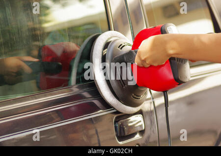 Mani tenendo un potere tampone di pulizia della macchina un auto Foto Stock