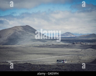 Lanzarote, Spagna - Agosto 23, 2016: Bus con i turisti che passano attraverso il paesaggio vulcanico del Parco Nazionale di Timanfaya Foto Stock