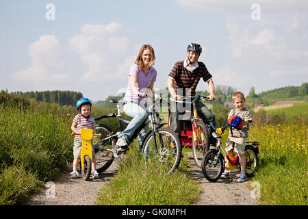 Famiglia equitazione biciclette in estate Foto Stock