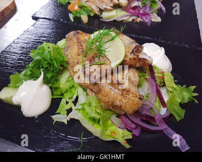 Zander insalata, fatta di insalata fresca, calce, decapare le cipolle rosse, bianco balsamico e maionese, presso un ristorante cucina Foto Stock