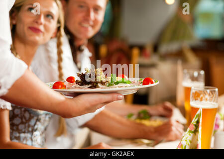 La cameriera che serve in pub bavarese Foto Stock