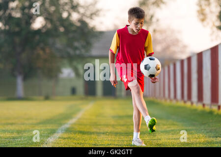 Bambini che giocano a calcio su un campo di calcio Foto Stock