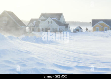 La scarsa visibilità con forti venti che spirano intorno neve durante una tempesta di neve in suburbia. Foto Stock