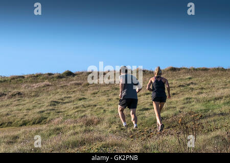 Le persone che eseguono su East pentire a Newquay, Cornwall. Foto Stock