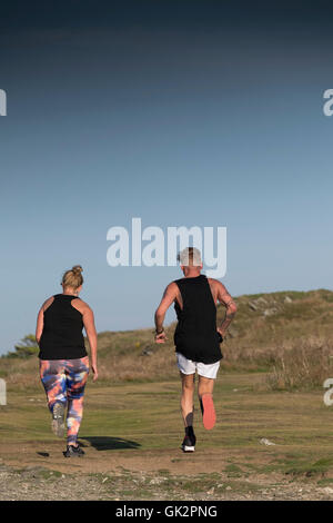 Le persone che eseguono su East pentire a Newquay, Cornwall. Foto Stock