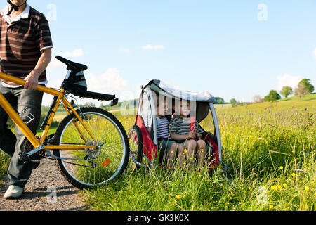 Gite in famiglia una bici in estate con rimorchio Foto Stock