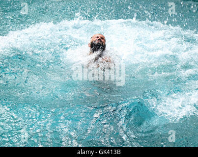 Uomo di uscire dall'acqua in una piscina Foto Stock