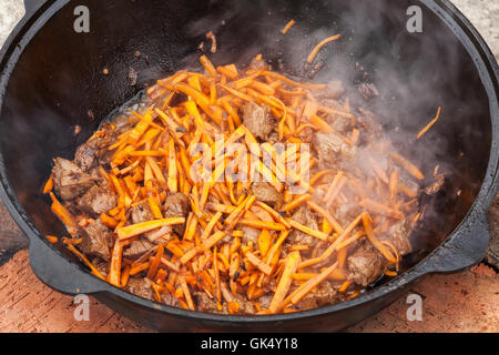 Pilaf, pilaw, plov, riso con carne in padella. Il processo di cottura Foto Stock