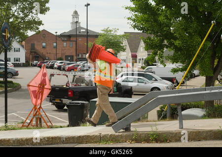 Operaio edile trasportano traffico coni. Foto Stock
