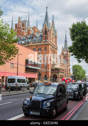 Nero, Londra taxi in coda sulla Euston Road con architettura gotica del St Pancras International Hotel dietro. Foto Stock