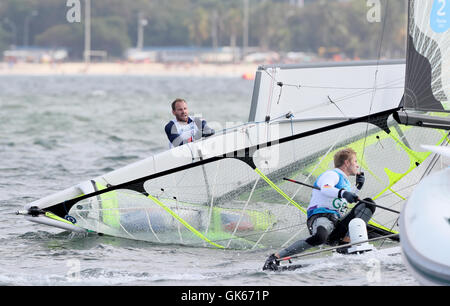 Gran Bretagna Dylan Fletcher-Scott e Alain segno provare a destra la loro barca dopo il naufragio durante gli uomini 49er Medal Race a Marina da Gloria il tredicesimo giorno del Rio Giochi Olimpici, Brasile. Foto Stock