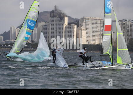 Gran Bretagna Dylan Fletcher-Scott e Alain segno provare a destra la loro barca dopo il naufragio durante gli uomini 49er Medal Race a Marina da Gloria il tredicesimo giorno del Rio Giochi Olimpici, Brasile. Foto Stock