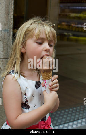 Adorabile ragazza giovane mangiando cioccolato cono gelato Foto Stock