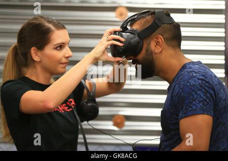 (160819)-- TORONTO, 19 Agosto, 2016(Xinhua) -- Un visitatore (R) cerca VR di apparecchiature al 2016 Canadian National Exhibition a Toronto, Canada, 19 Agosto, 2016. Come una delle più grandi mostre in Canada, questo annuale 18-evento della durata di un giorno che ha dato dei calci a fuori il venerdì è atteso per attirare più di un milione di visitatori provenienti da tutto il mondo. (Xinhua/Zou Zheng) Foto Stock