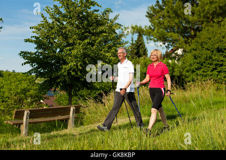 Felice coppia di anziani nordic walking in estate Foto Stock