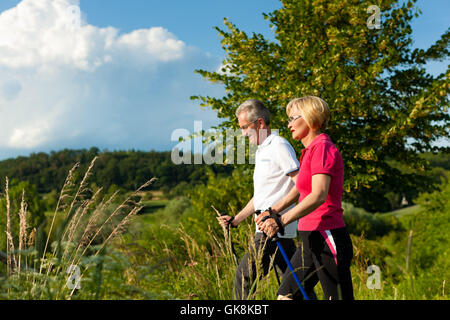 Felice coppia di anziani nordic walking in estate Foto Stock