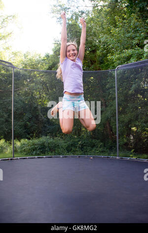 Ragazza giovane di saltare sul trampolino Foto Stock