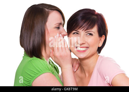 Le donne visto sussurra all'orecchio Foto Stock