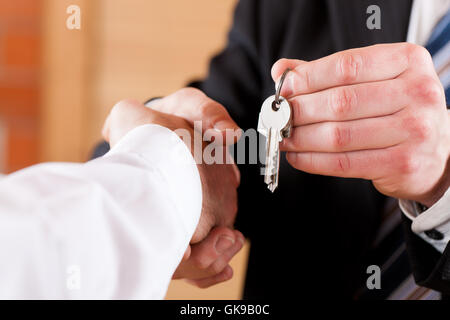 Stretta di mano in business con i tasti Foto Stock