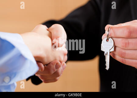 Stretta di mano in business con i tasti Foto Stock