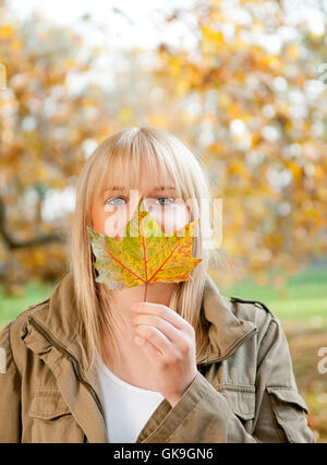 Giovane donna con foglie di autunno Foto Stock