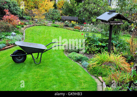 Giardinaggio con carriola in autunno giardino Foto Stock