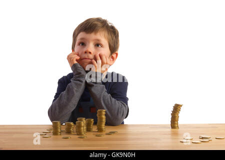 Un ragazzo seduto di fronte a molti soldi vertaumt pile Foto Stock