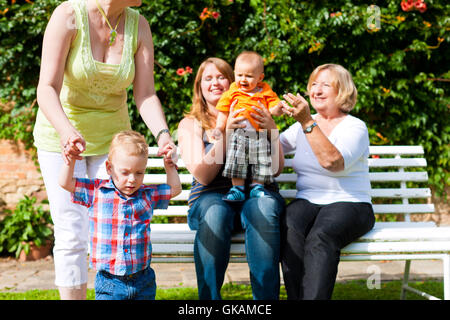 Due madri con la nonna e i bambini nel parco Foto Stock