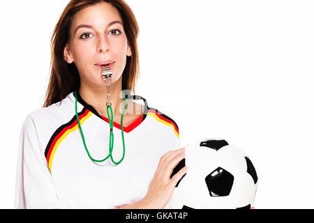 Giovane donna con un fischio tenendo il calcio Foto Stock