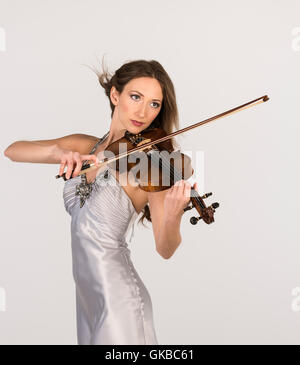 Giovani brunette in un abito bianco la riproduzione di un violino in studio, Virginia Beach, Foto Stock