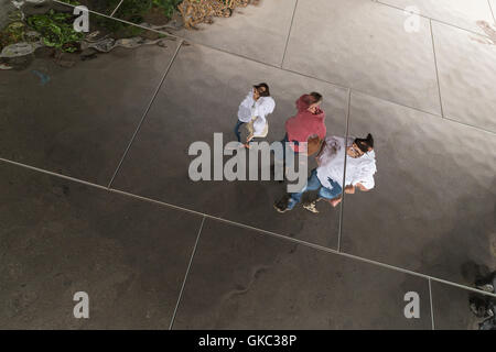 Contorte riflessioni di persone in un soffitto con specchi Foto Stock