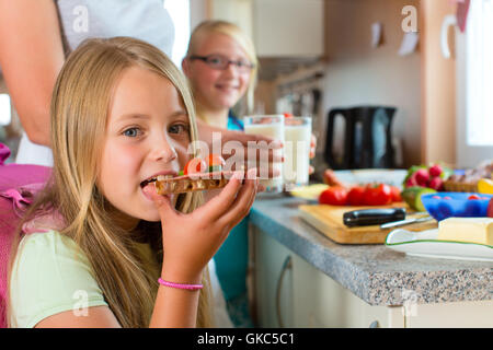 Famiglia - madre prepara la colazione per la scuola Foto Stock