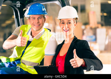 Driver di carrello elevatore a forche e collega,in stoccaggio di freight forwarding Foto Stock