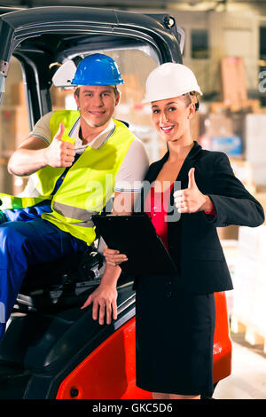 Driver di carrello elevatore a forche e collega,in stoccaggio di freight forwarding Foto Stock